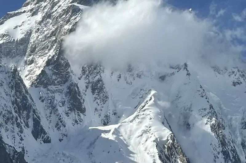 Majestic K2 mountain peak with clouds circling its summit, showcasing the impressive snow and ice formations in the Karakoram range, Pakistan